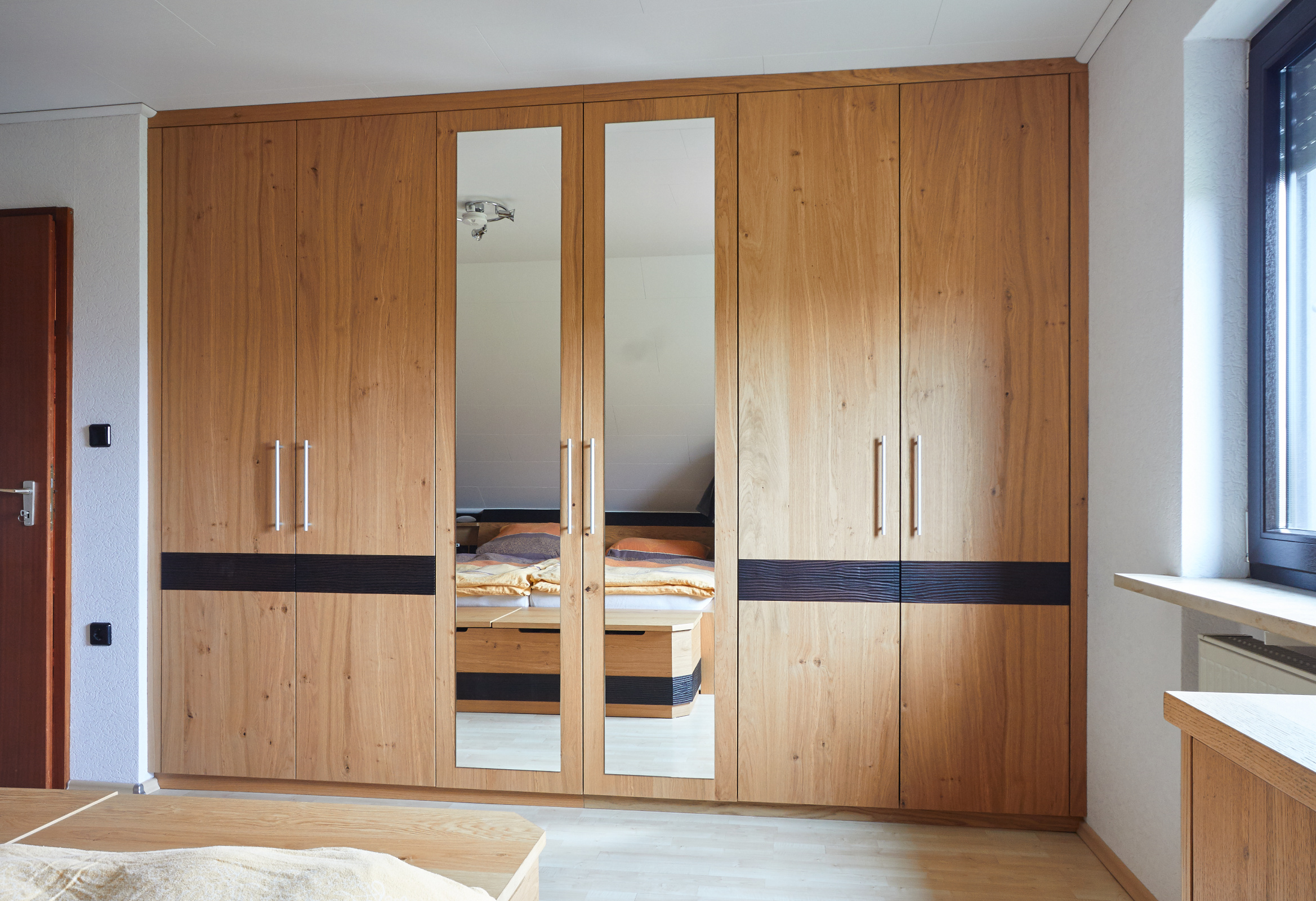 Schlafzimmer Eiche astig furniert, matt lackiert, Dekoelemente in Eiche gebeizt mit Wellenfräsung