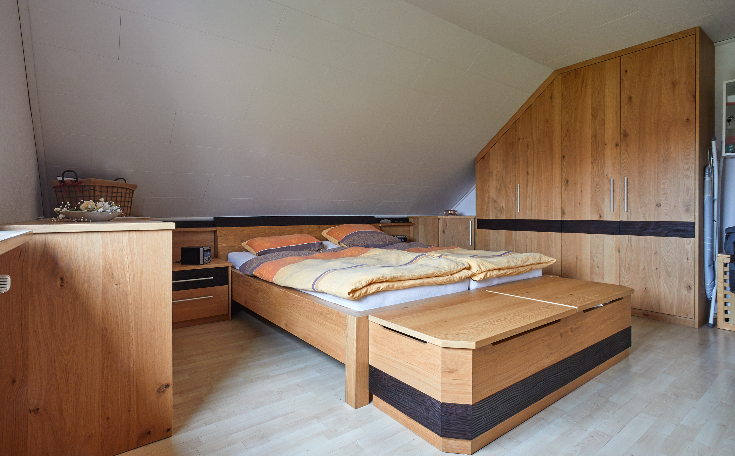 Schlafzimmer Eiche astig furniert, matt lackiert, Dekoelemente in Eiche gebeizt mit Wellenfräsung