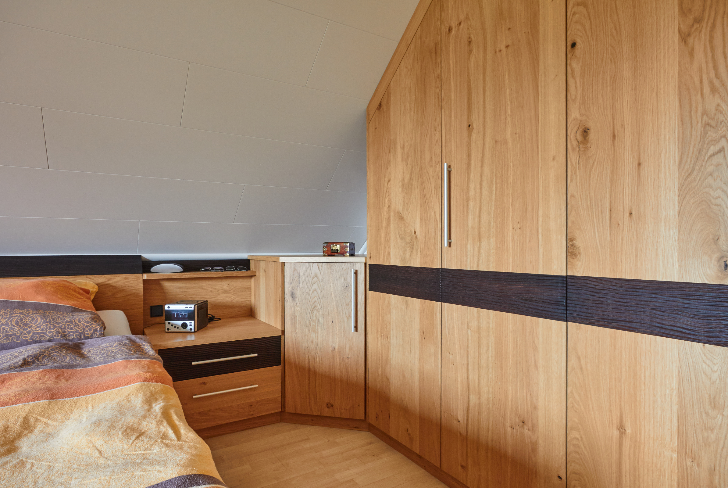 Schlafzimmer Eiche astig furniert, matt lackiert, Dekoelemente in Eiche gebeizt mit Wellenfräsung